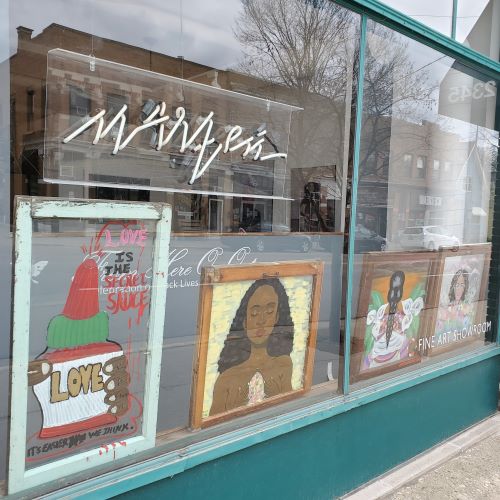 A shop window with framed art displaying
